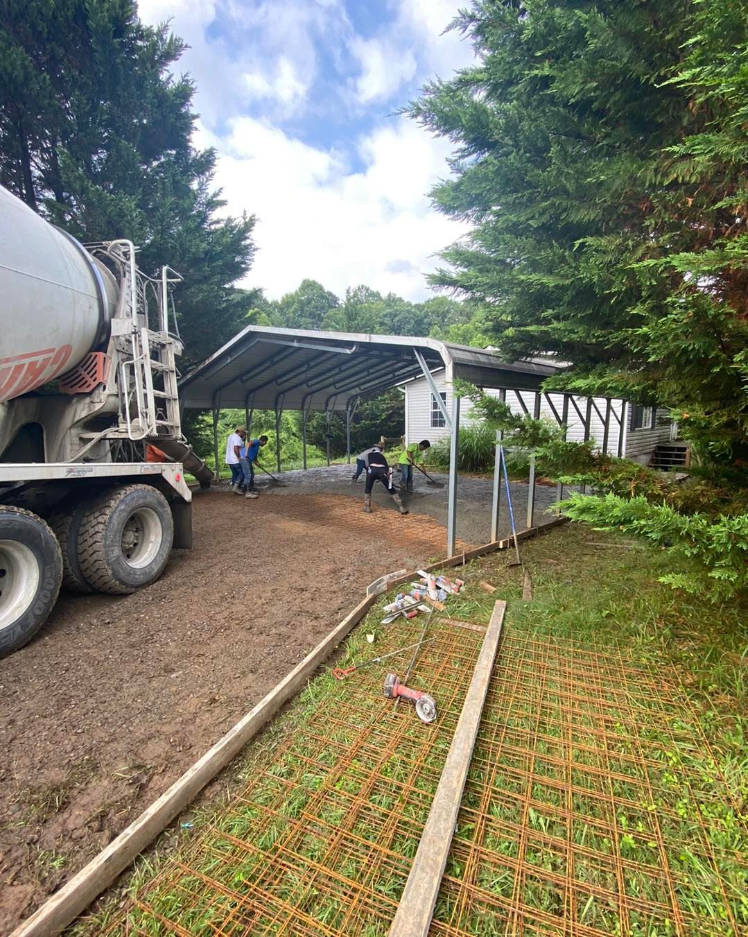 A group of construction workers are working on a concrete walkway.