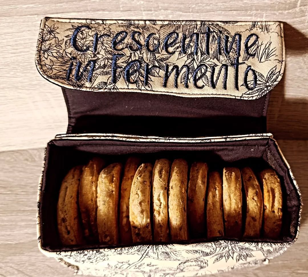 Vari vasetti di marmellata con cucchiai di legno su un tagliere, con uova e caffè sullo sfondo.