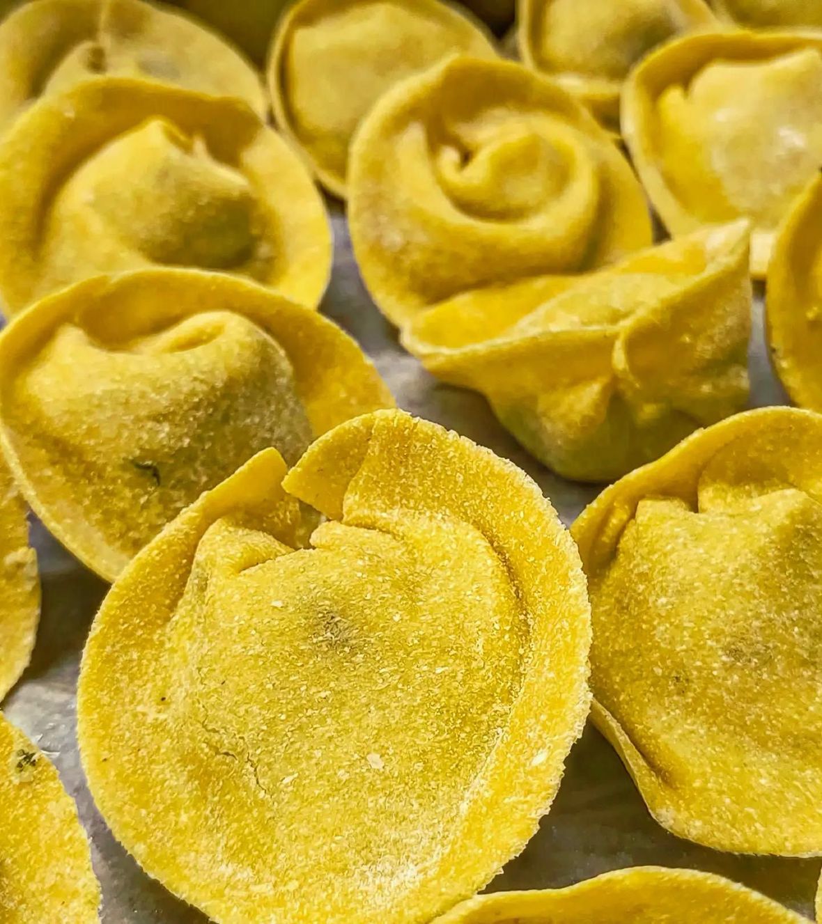 Menù di nozze piegato su un tavolo bianco con posate e piatti d'argento.