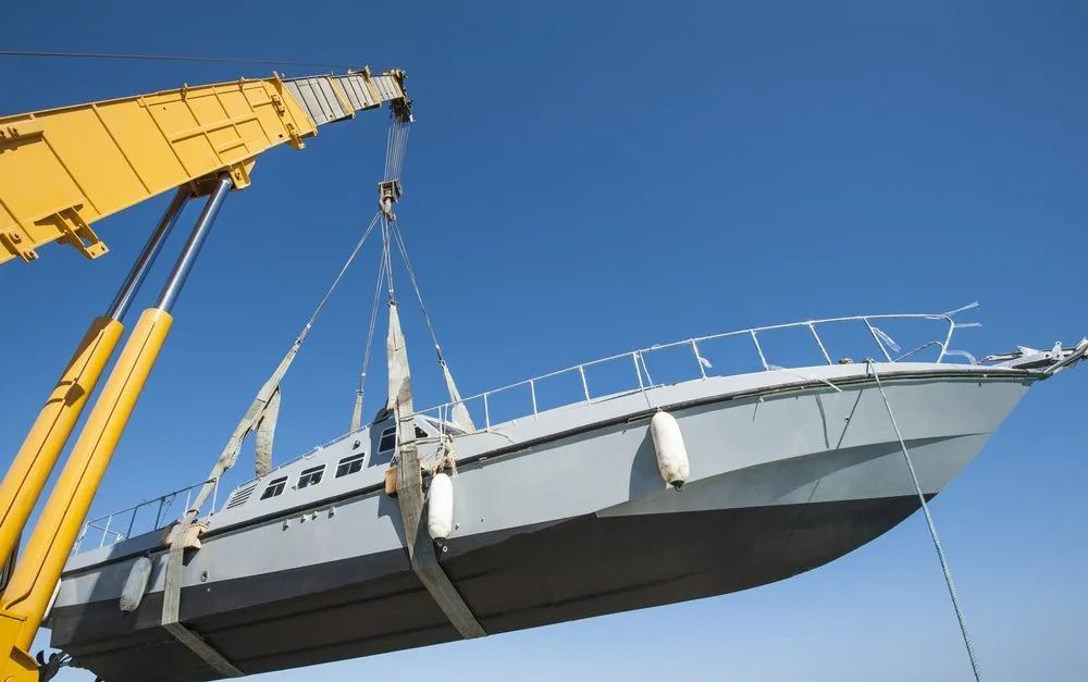 A boat is being lifted by a crane — ElectroMech Machine in Woolner, NT