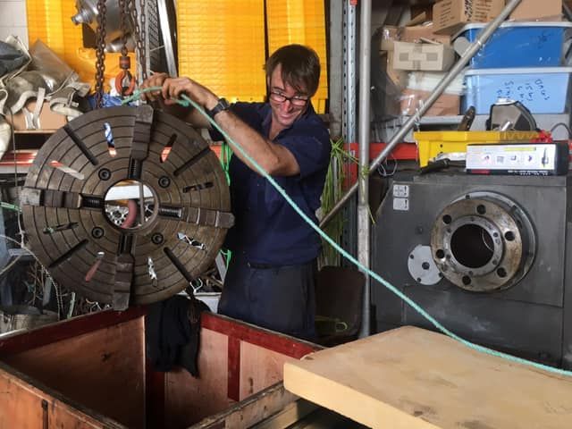 A Man is Working on a Machine With a Green Hose — ElectroMech Machine in Woolner, NT