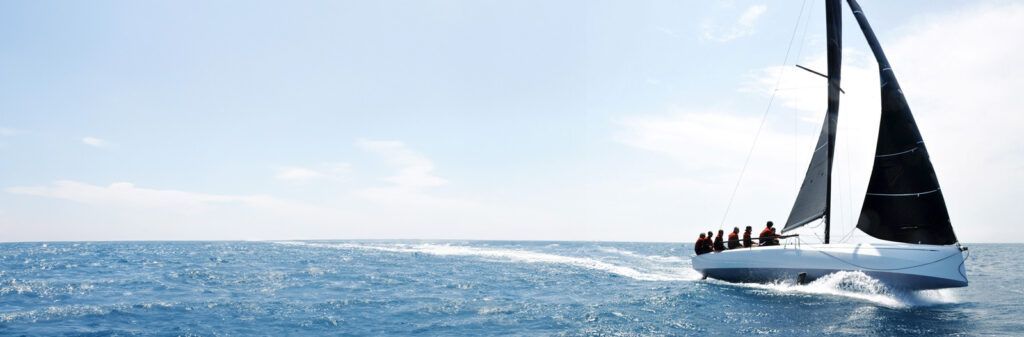 Sailboat With Black Sails Gliding Across a Bright Blue Ocean Under a Clear Sky — ElectroMech Machine in Woolner, NT