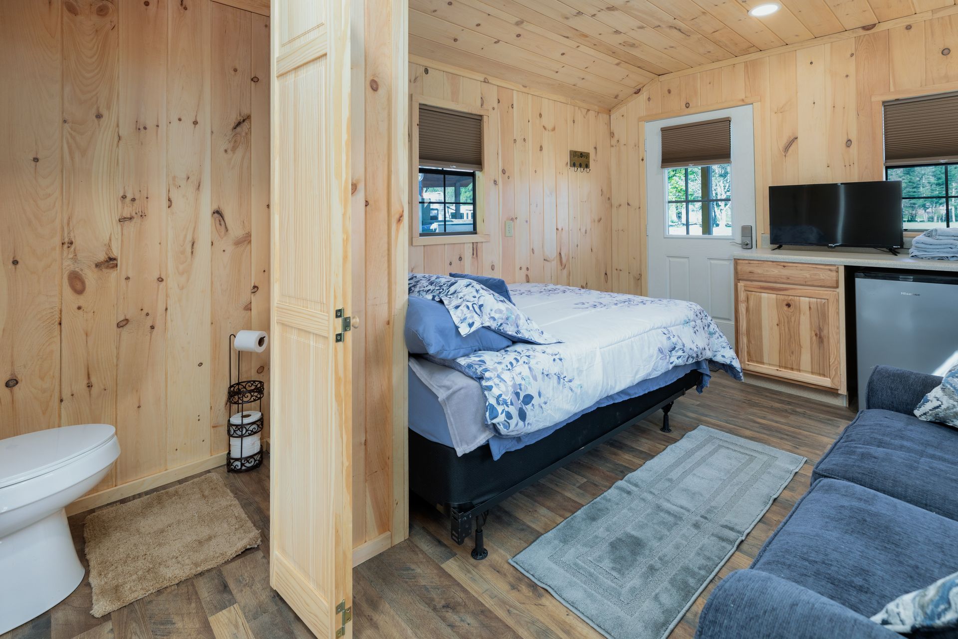 A bedroom with a bed , couch , toilet and bathroom.