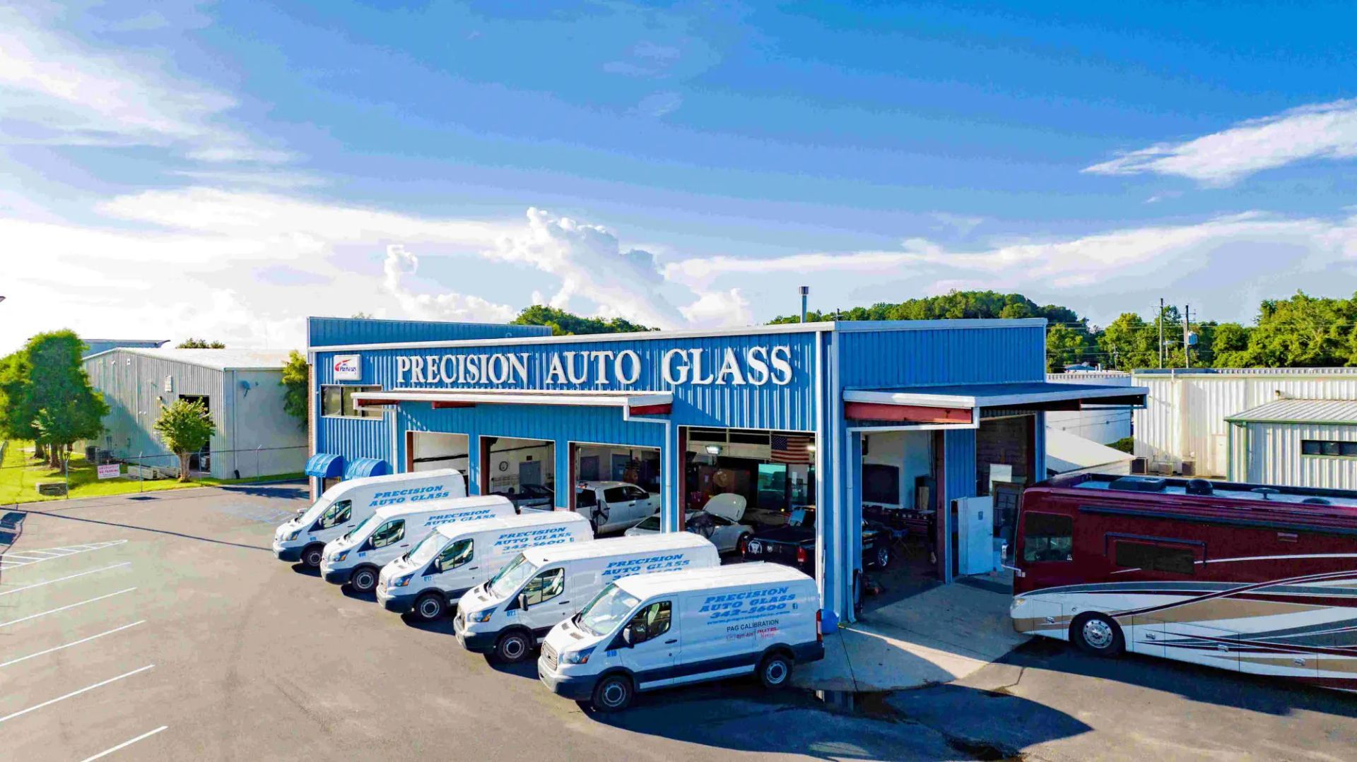 Ferguson Auto Glass building with vans, RV and trees.