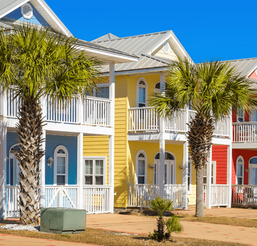 Colorful florida houses painted blue, yellow and red, palm trees in front. 