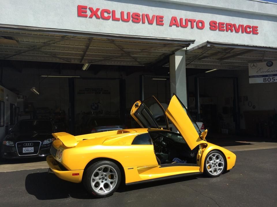Yellow Lamborghini with doors up in front of 