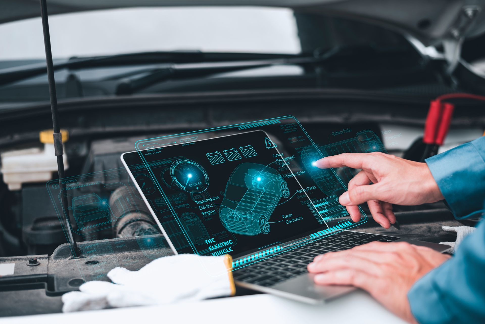 Mechanic uses a laptop with diagnostic software under a car hood. Blue-lit screen displays engine data. Mechanic uses a laptop with diagnostic software under a car hood. Blue-lit screen displays engine data.