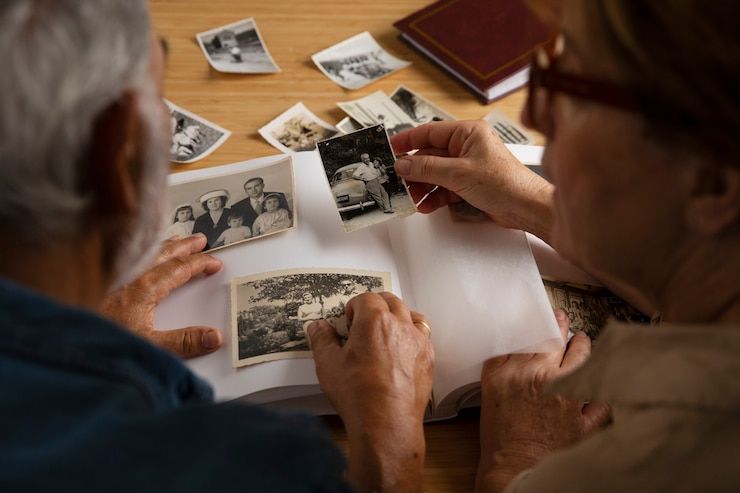 An elderly couple is looking at old photos together.