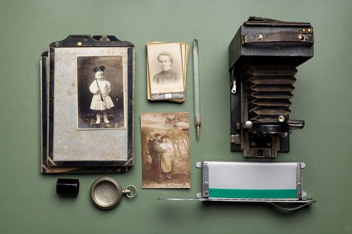 A collection of old photographs and a camera on a table