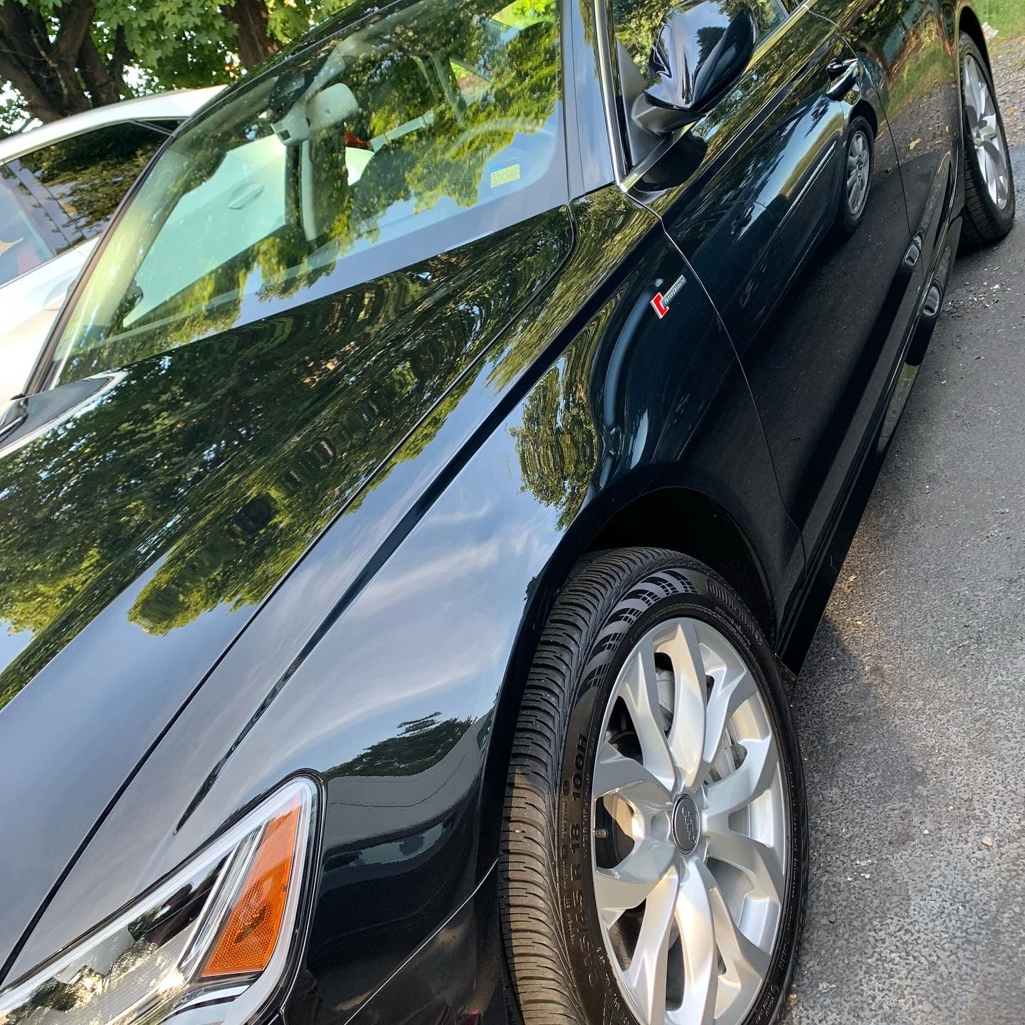 A black car is parked on the side of the road