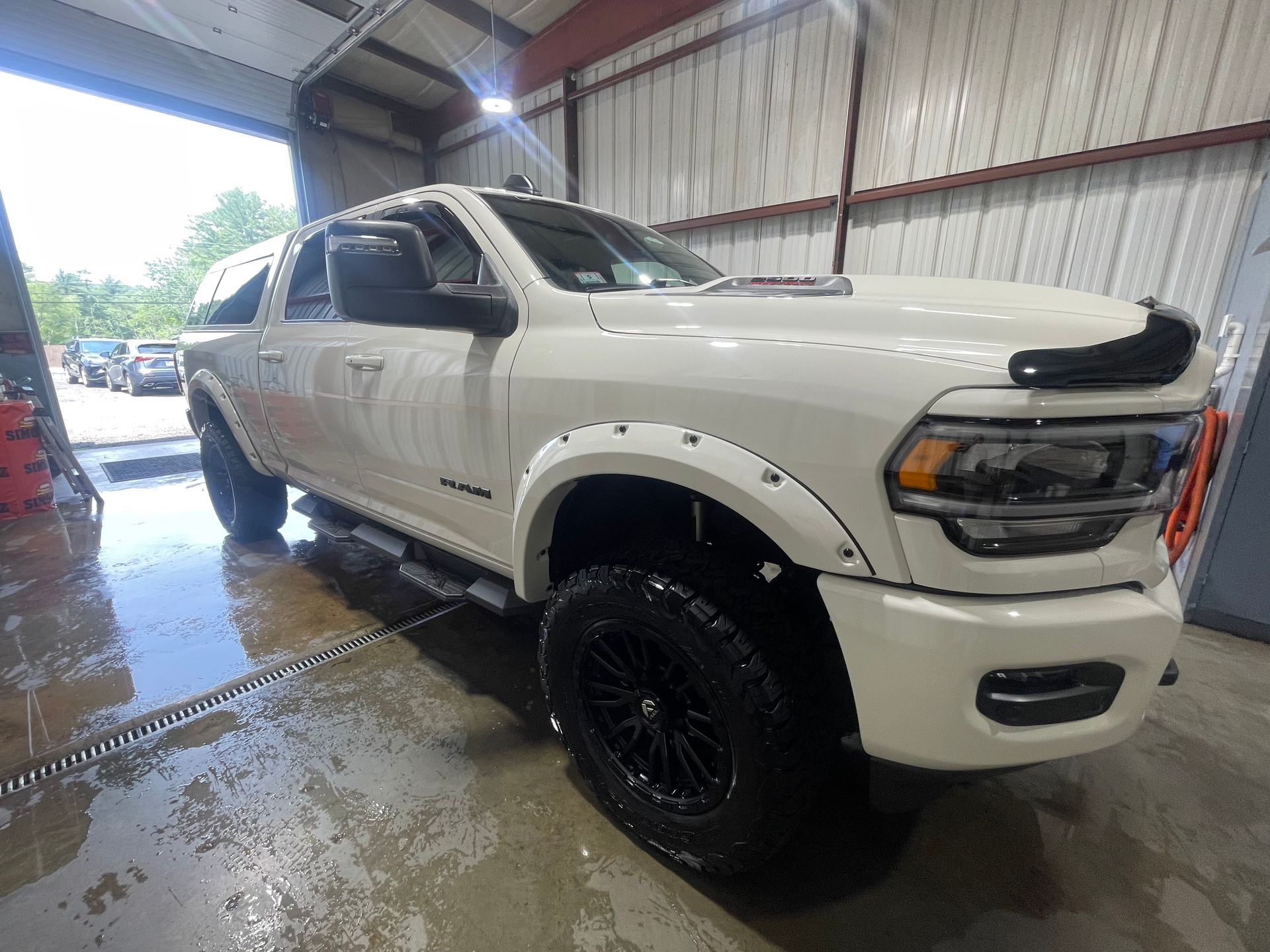 A white dodge ram truck is parked in a garage.