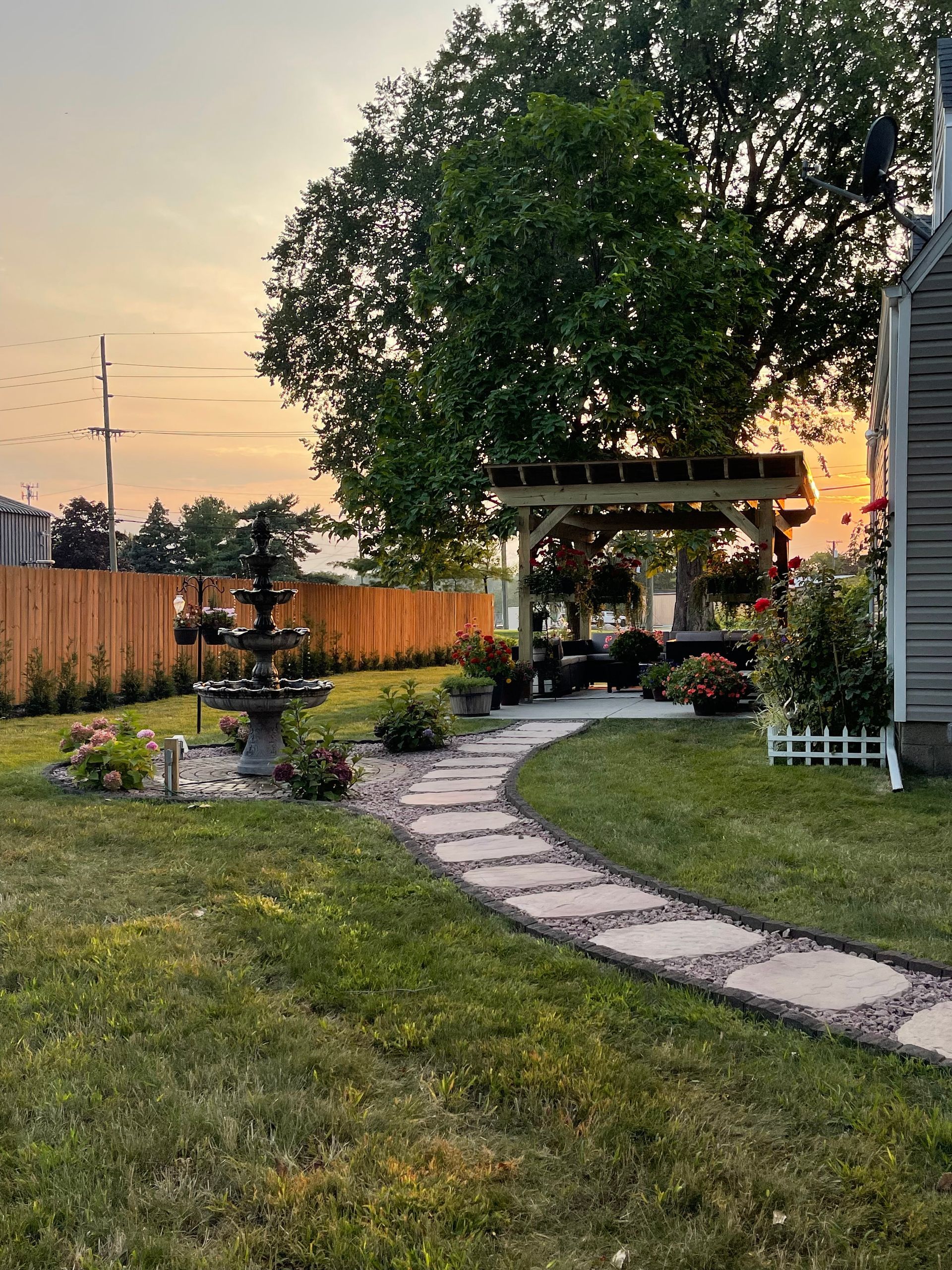 There is a fountain in the middle of the backyard.