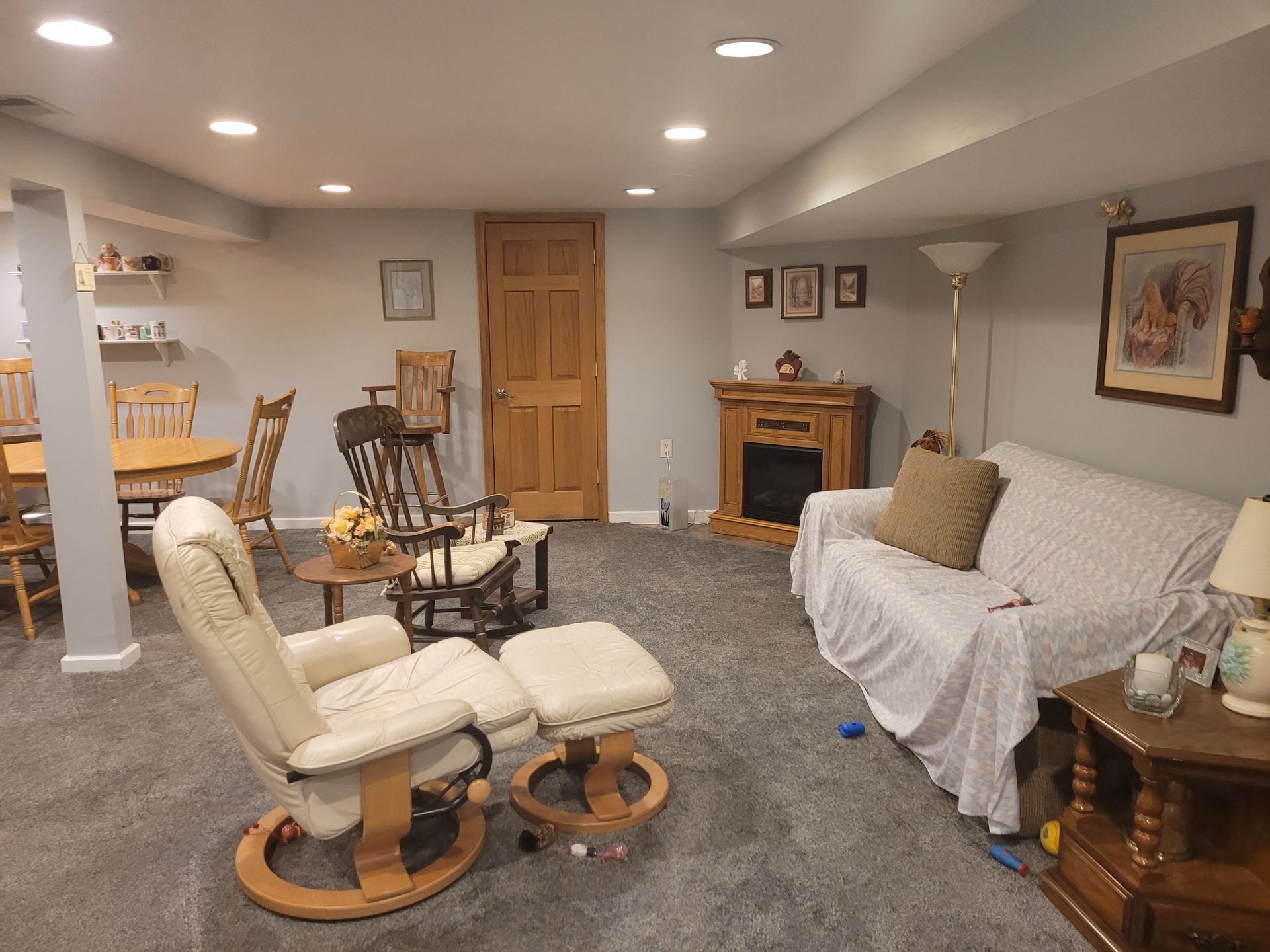 A living room with a couch , chair , table and fireplace.