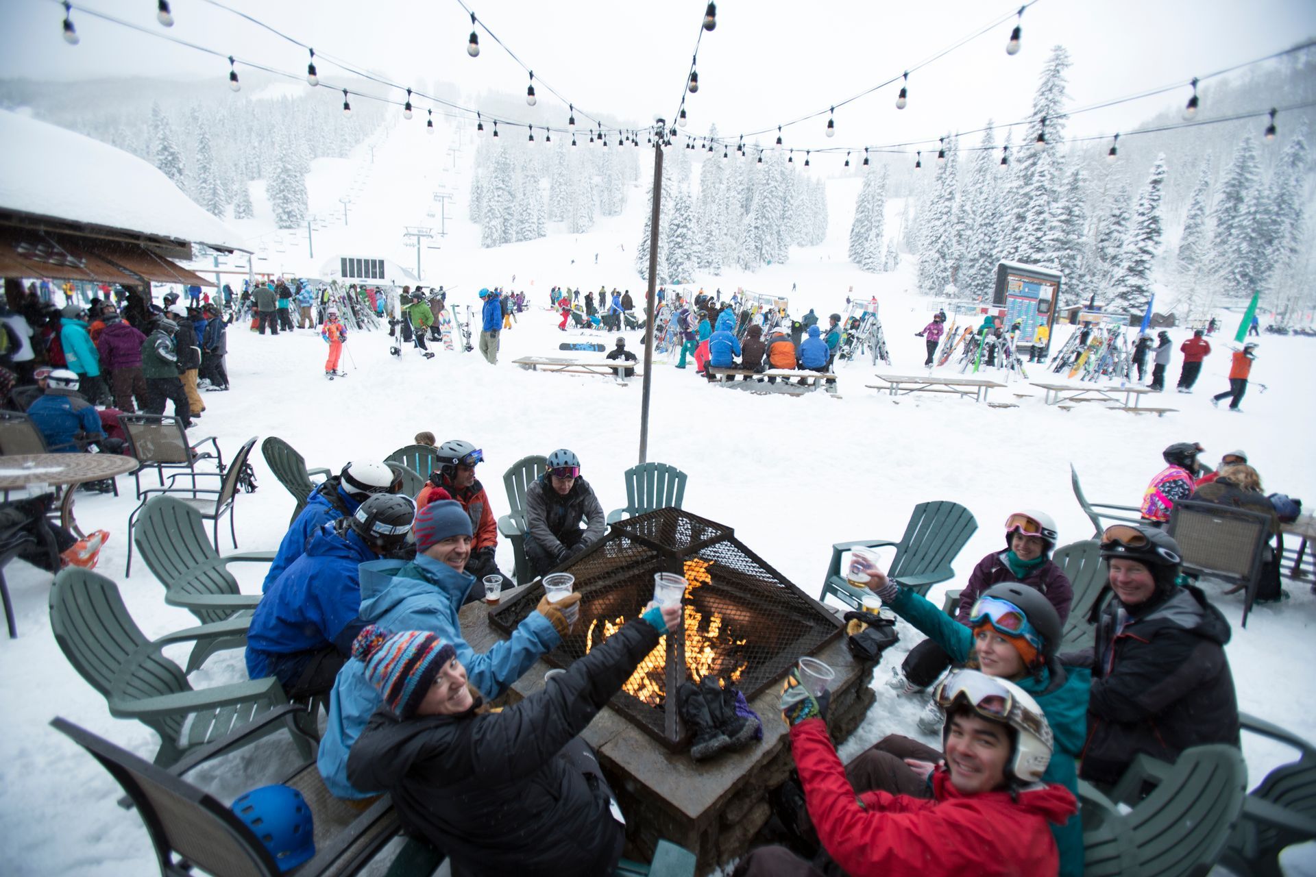 A group of people are sitting around a table in the snow.