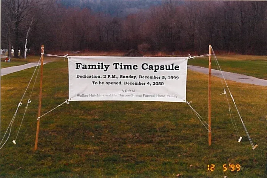 “Family Time Capsule” banner on a grassy field between tents and ropes at dusk
