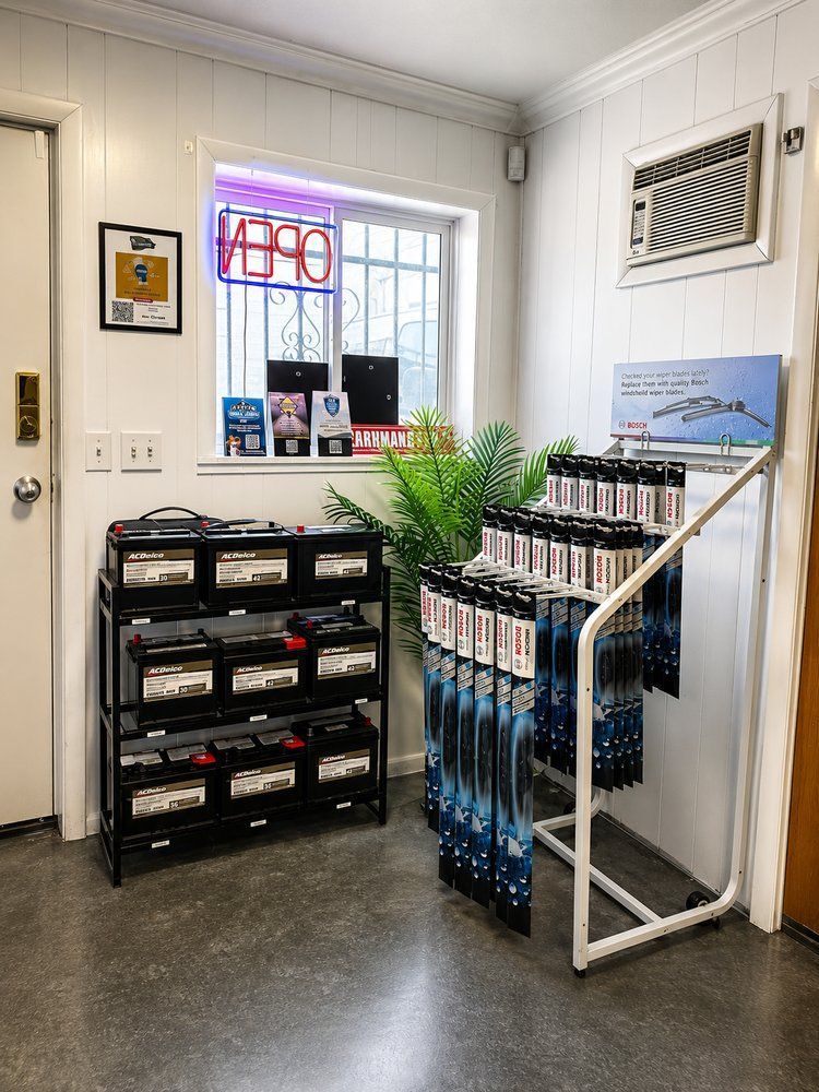 Small shop interior with shelves of supplies, hanging blue items, and a windowed wall | Perryman Auto Repair