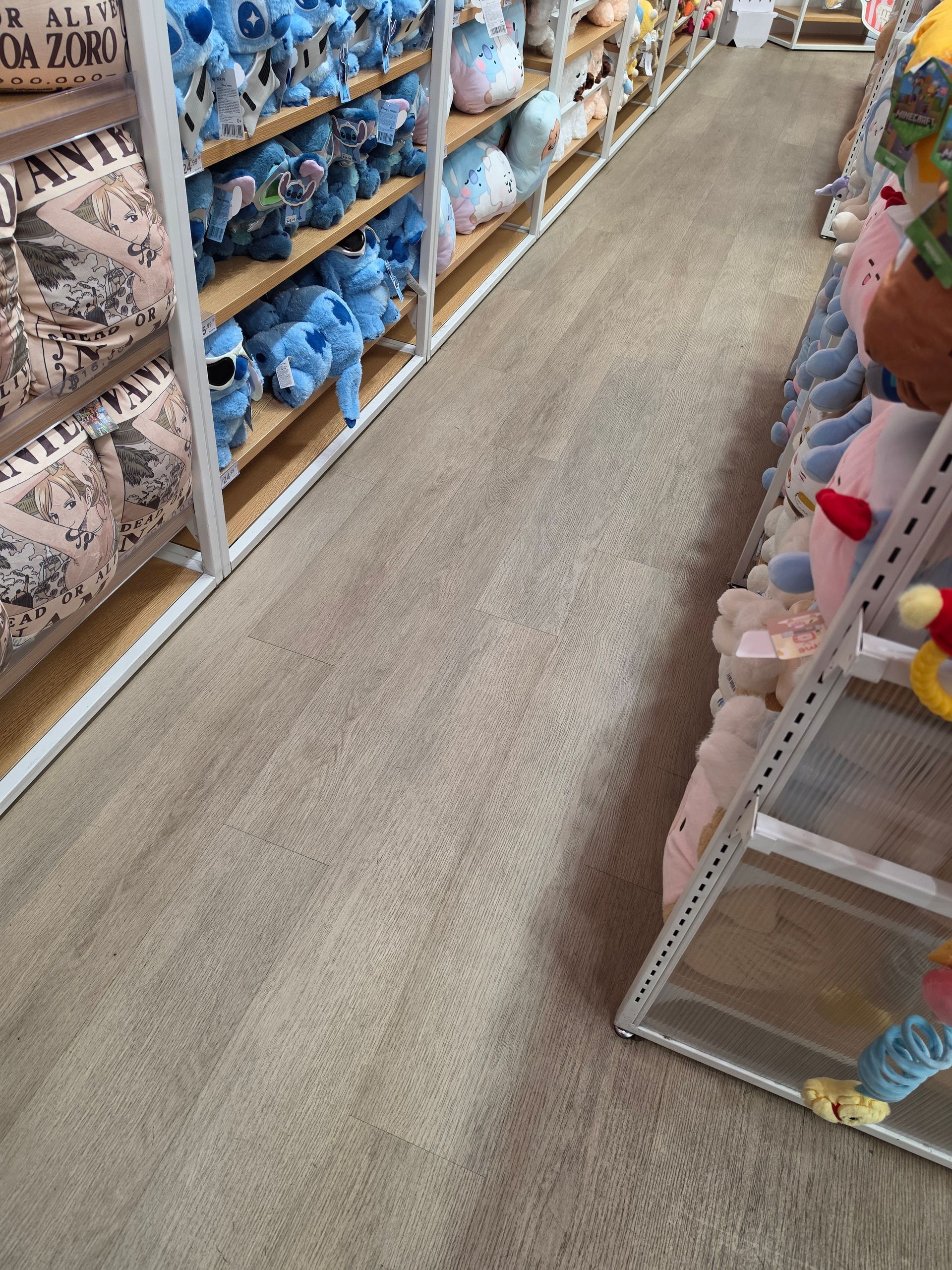 Store aisle with shelves of plush toys and a carpeted walkway