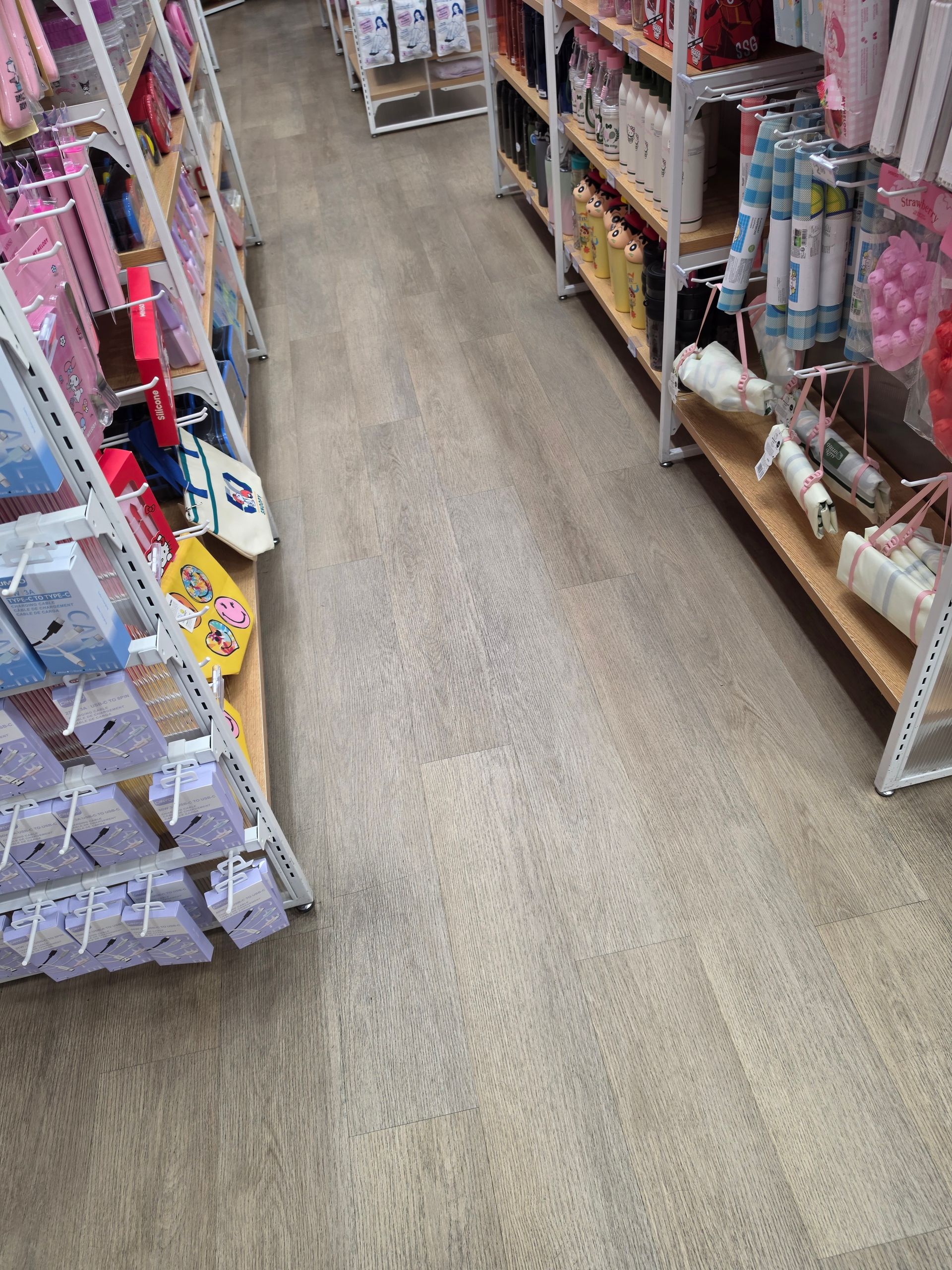 Aisle in a store with shelves of colorful packaged goods on both sides.