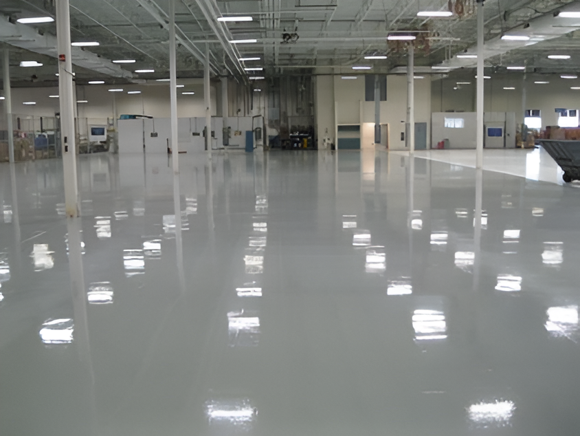 Empty glossy industrial warehouse with white floors and overhead lights