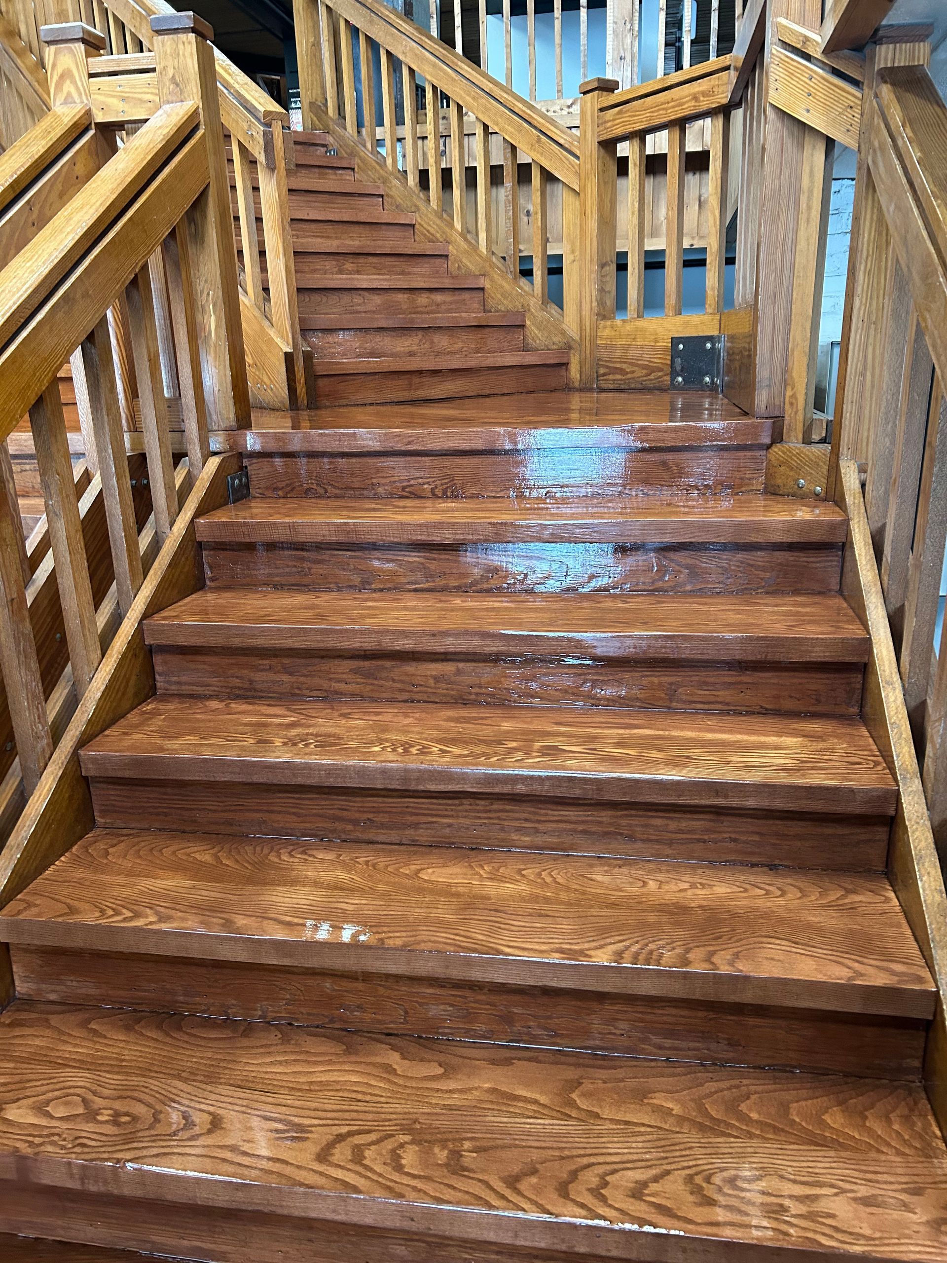 Wet wooden staircase with railings and blue reflections on the steps