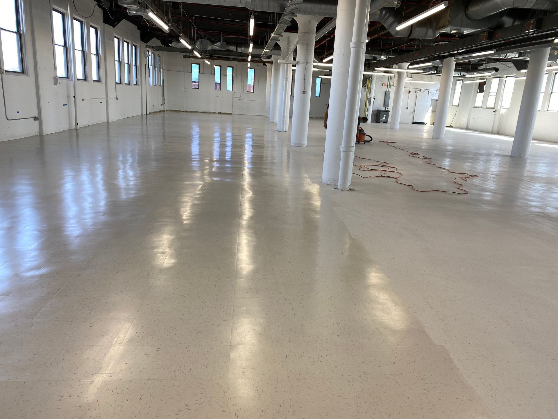 Empty industrial warehouse with polished concrete floor and white support columns