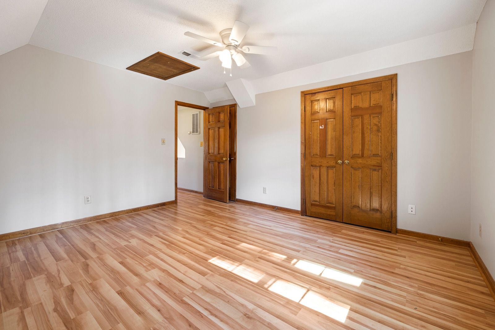 Partially finished room with orange subfloor, exposed walls, and a central metal floor mount
