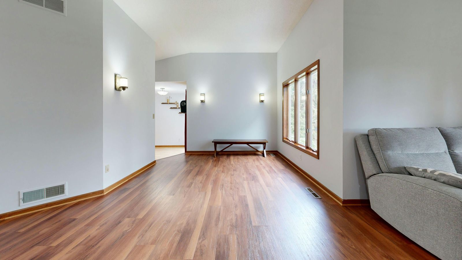 Wooden staircase with white trim and a dark wall, featuring a central square newel post.
