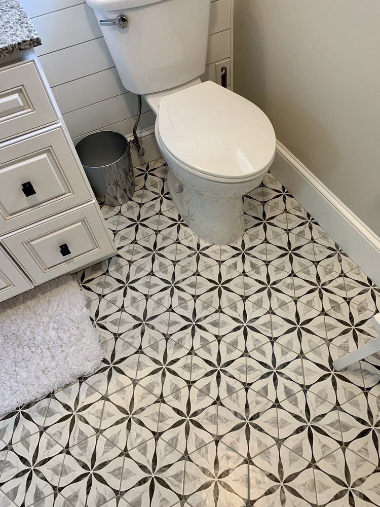 Modern white-tiled walk-in shower with bench, mosaic accent wall, and black fixtures