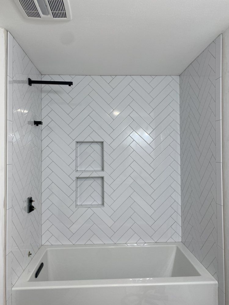 Modern gray-tiled shower with built-in bench, wall niches, and overhead fixtures