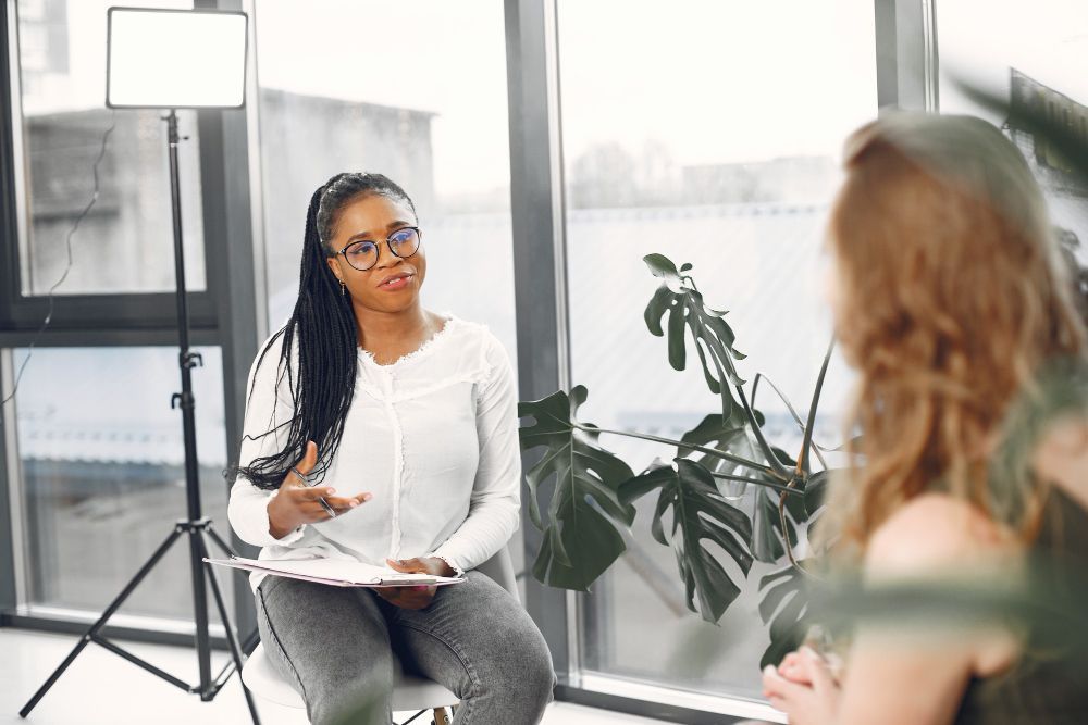 Young Black woman in a white t-shirt in a therapy session