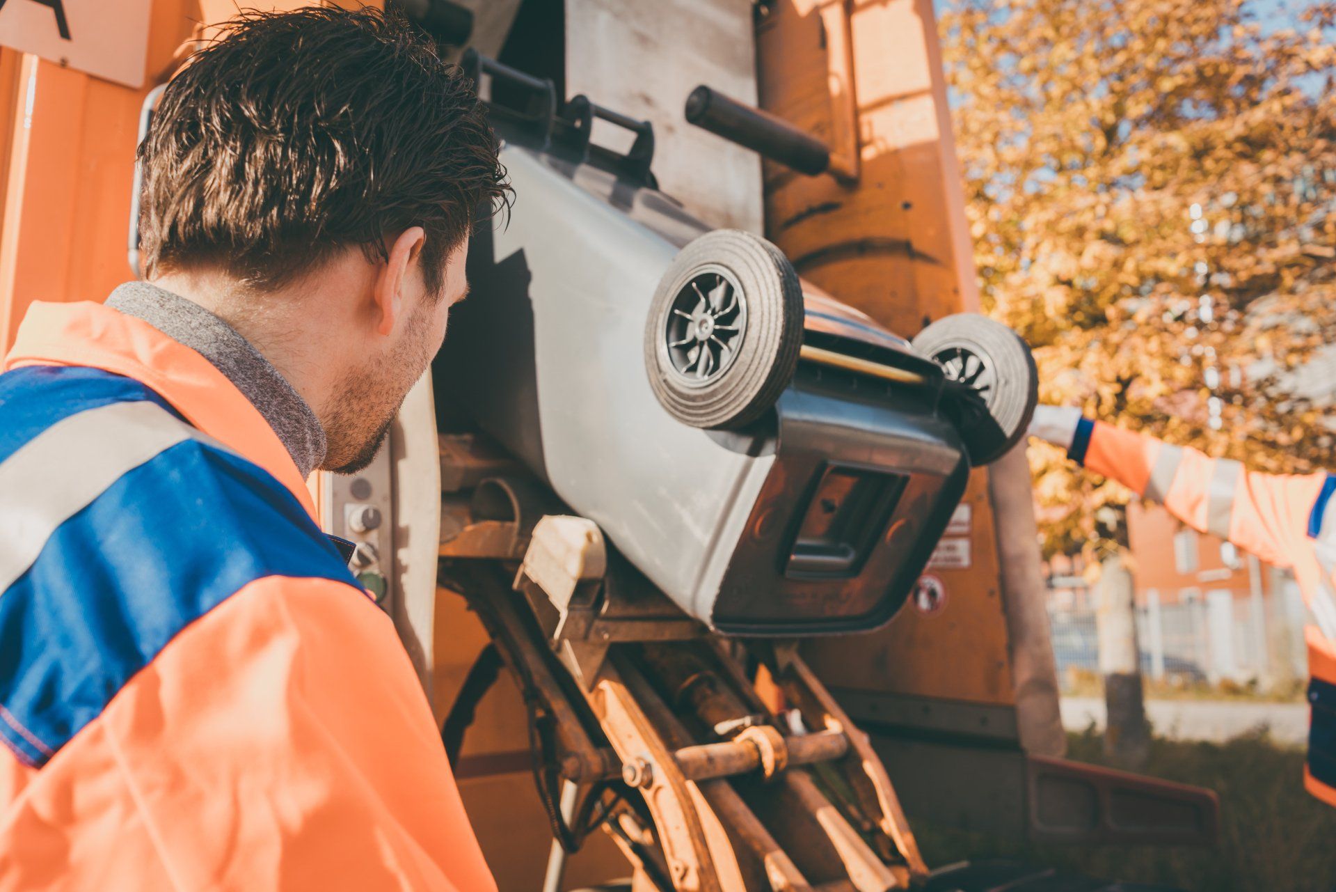 man standing beside the garbage truck