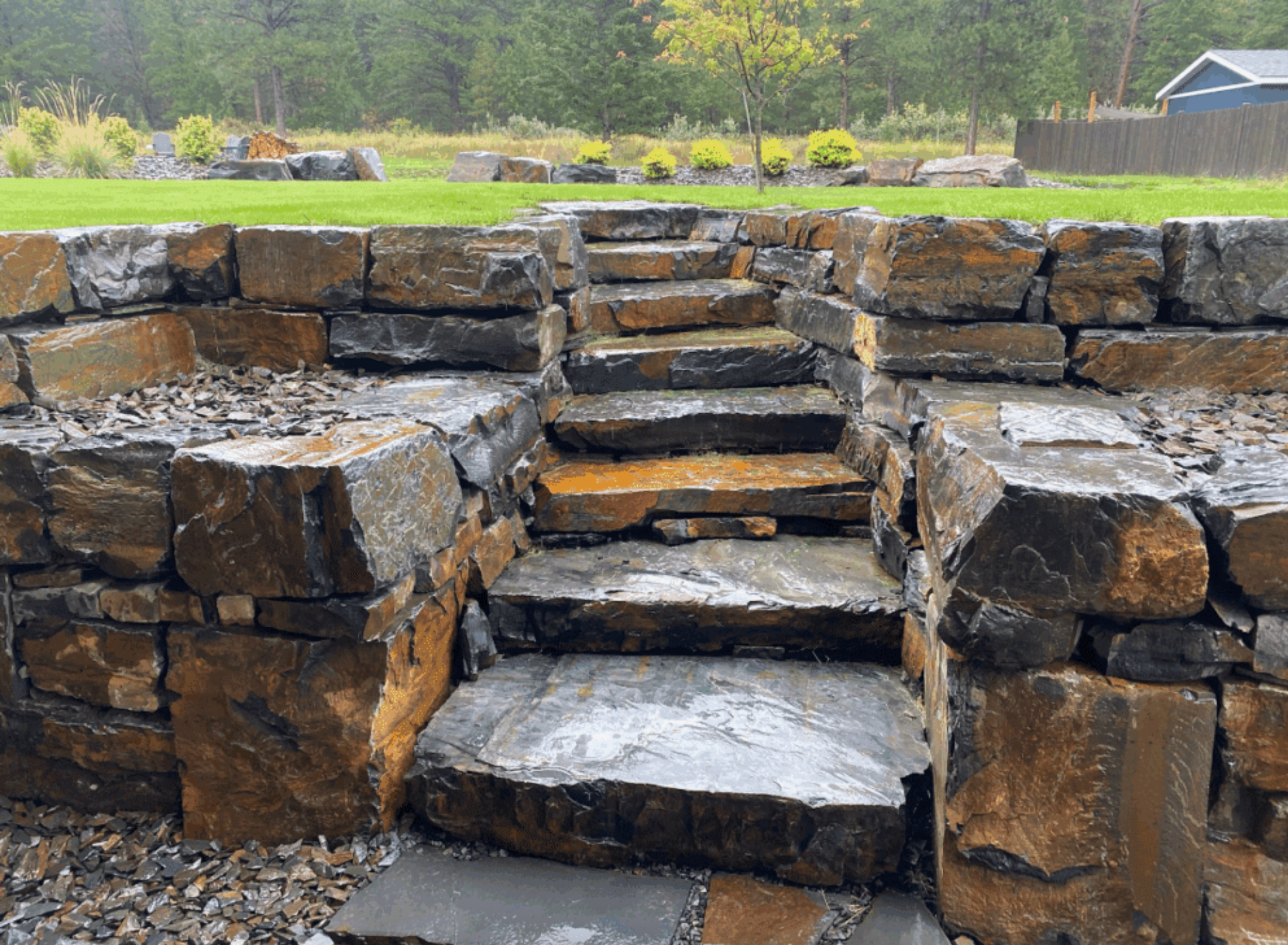 Stone steps built into a rock retaining wall in a landscaped garden park