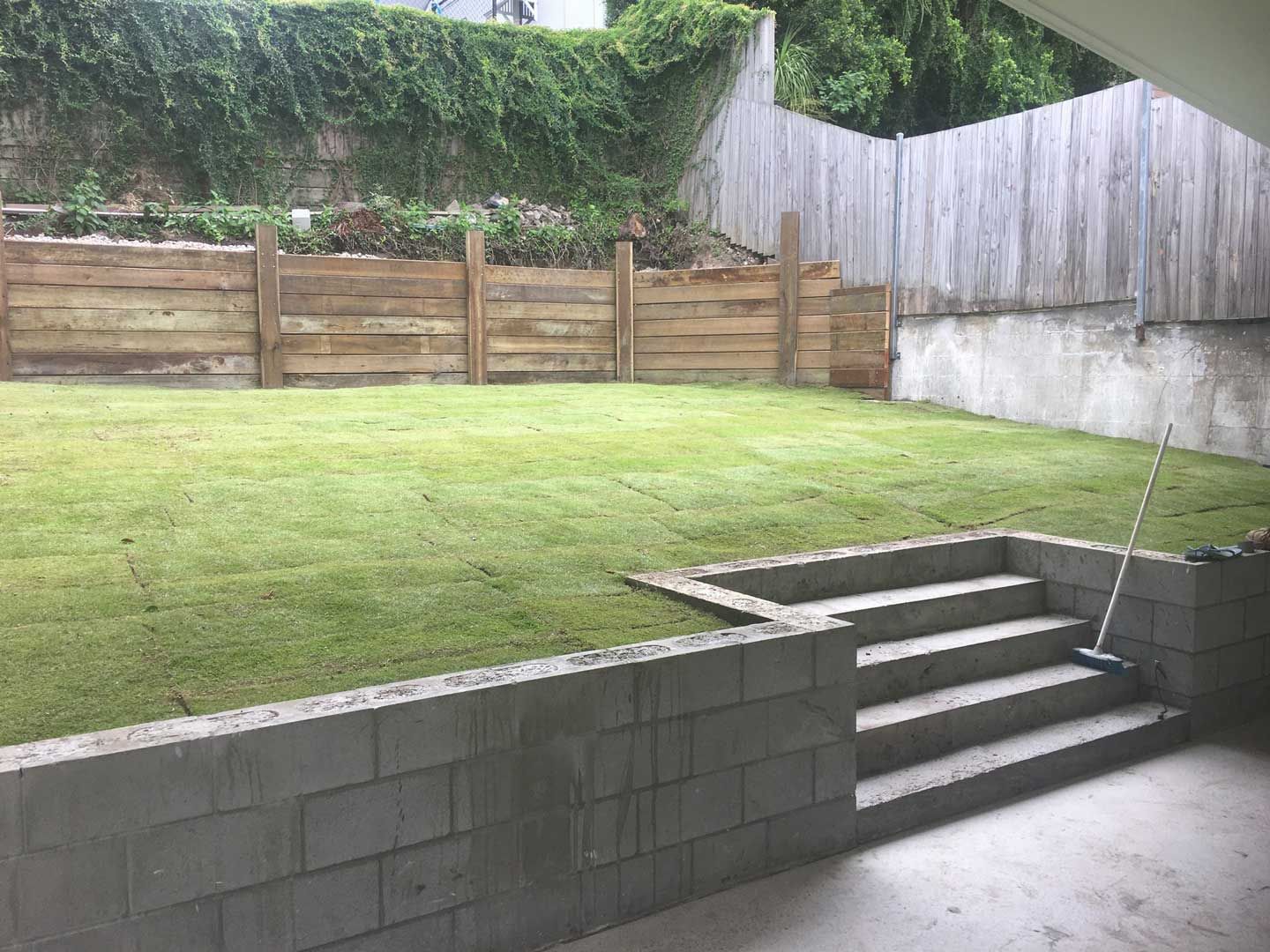 Landscape with Retaining Wall and Timber Fence — Landscaper in Bundaberg, QLD