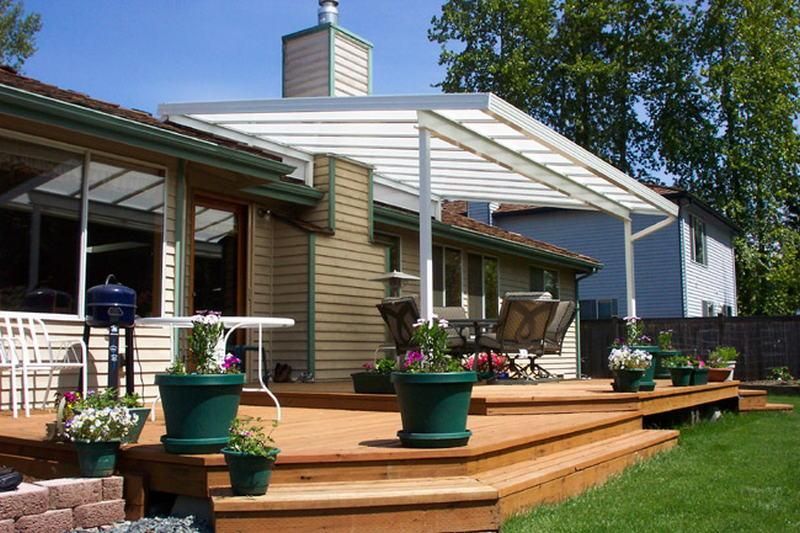 A house with a covered deck and potted plants