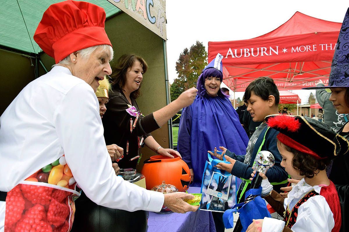 A woman in a chef 's hat is handing out candy to children