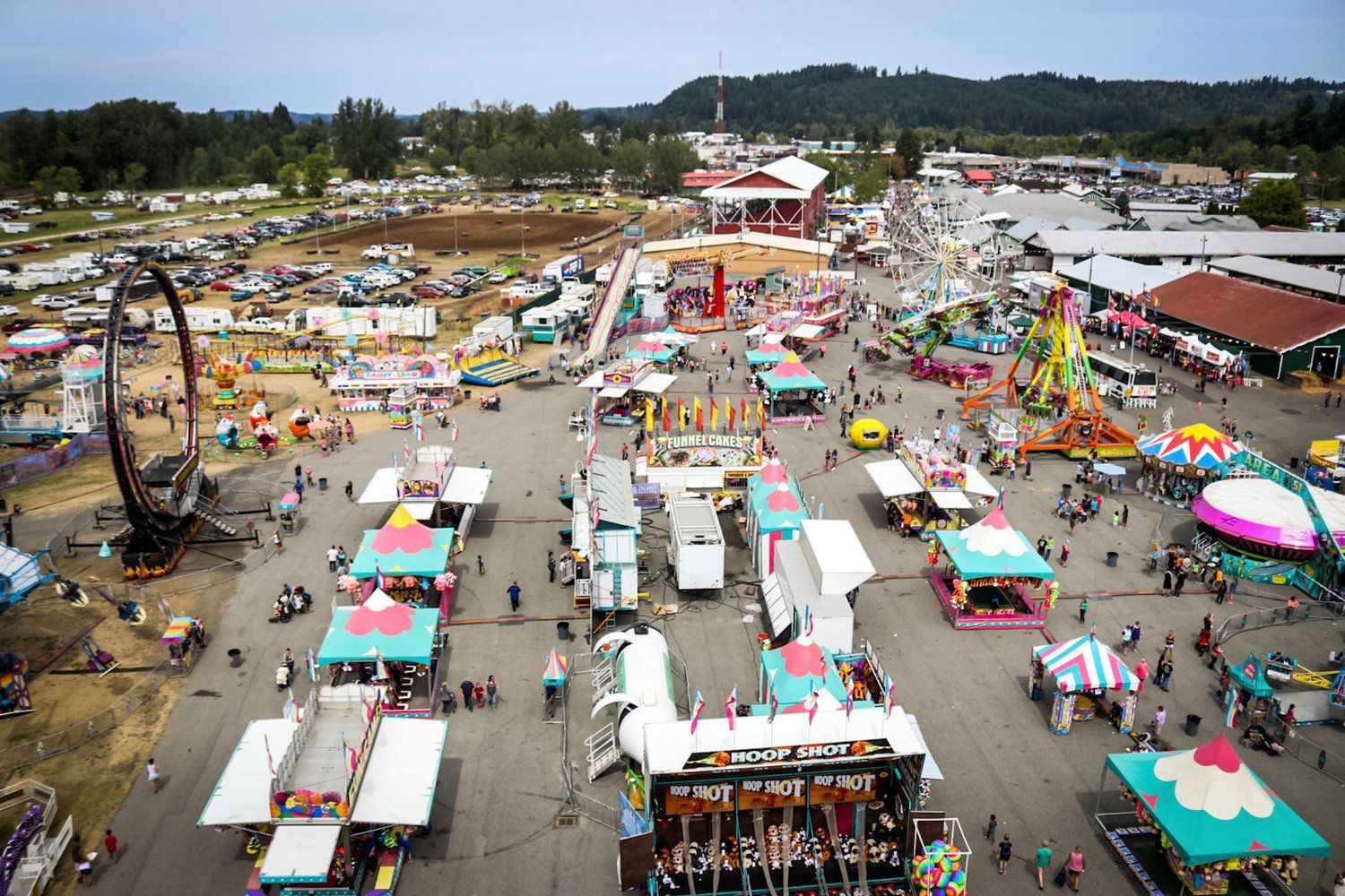 An aerial view of a carnival filled with people and rides.