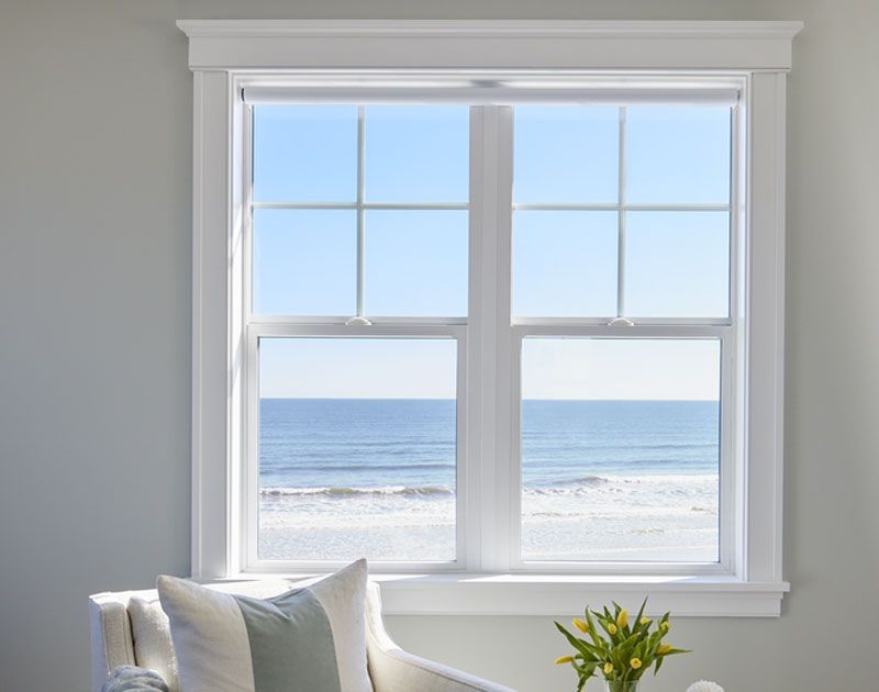 A living room with a large window overlooking the ocean.