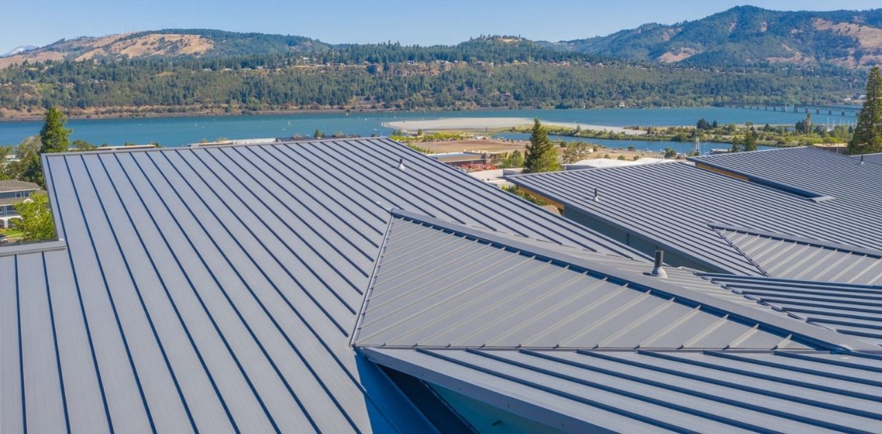 An aerial view of a roof with a view of a lake and mountains.
