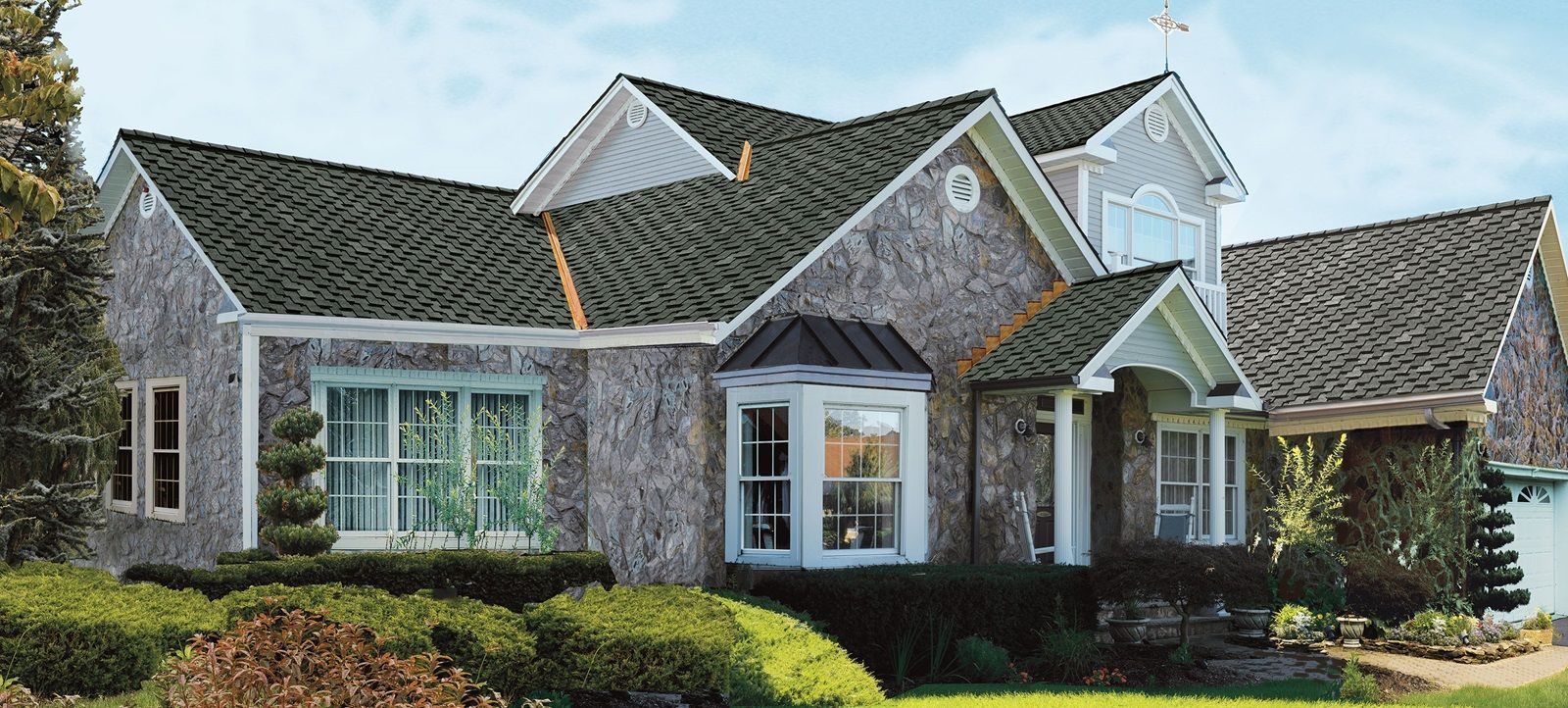 A large brick house with a green roof and white trim