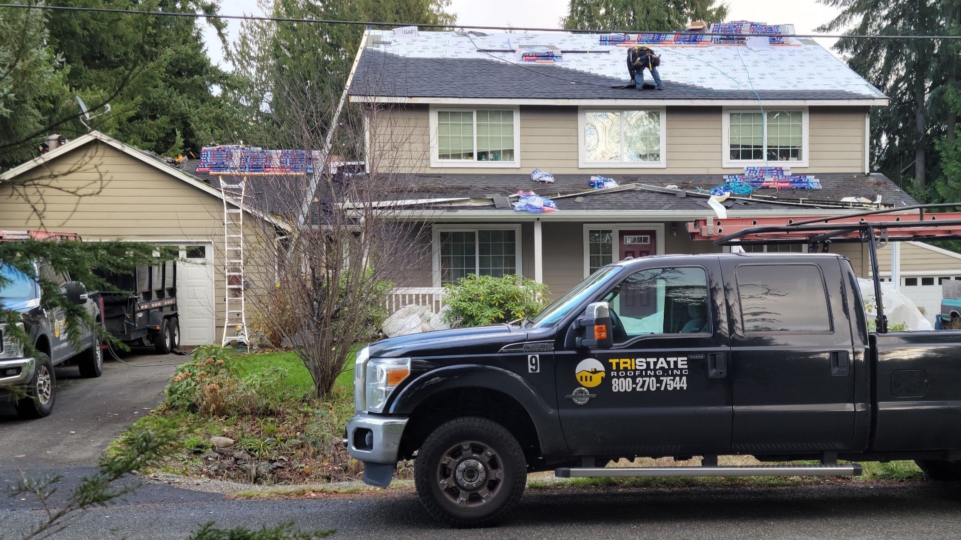 A black truck is parked in front of a house.