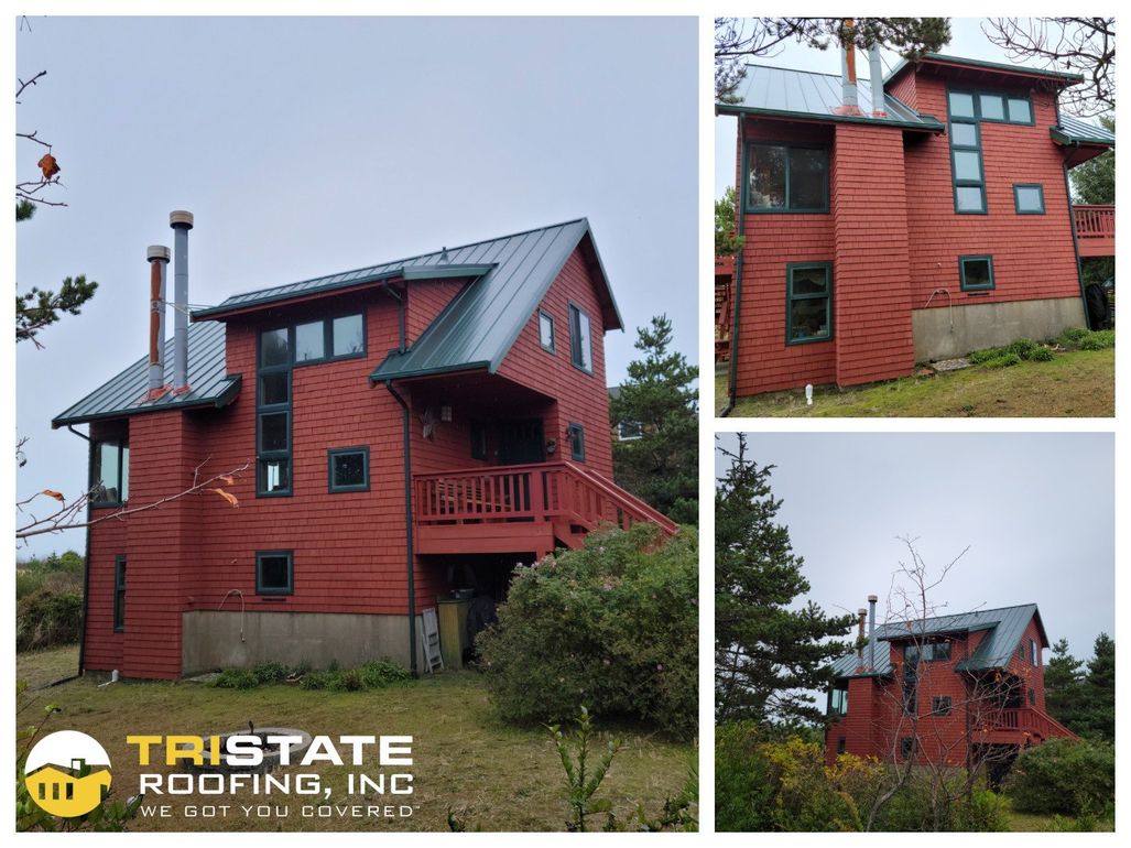 A red house with a metal roof is sitting on top of a hill.