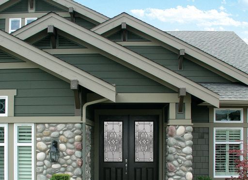 A house with a stone wall and a black door