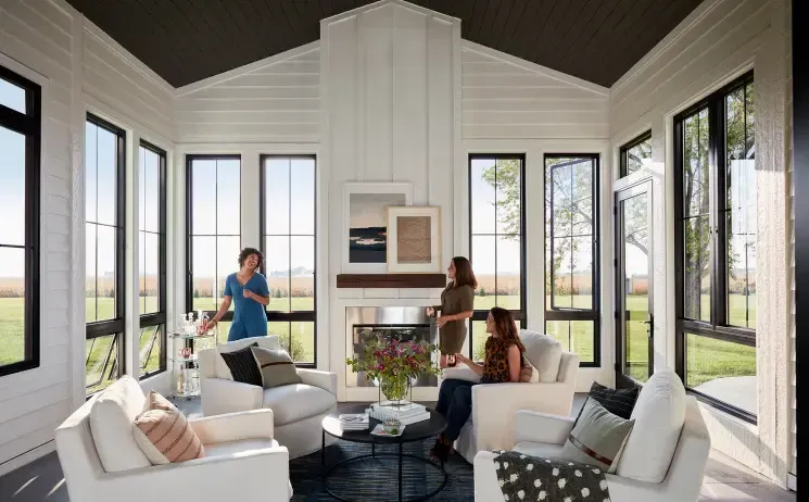 A group of people are sitting in a living room with a fireplace.
