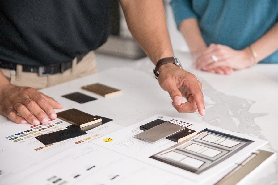 A man and a woman are looking at a drawing of a house.