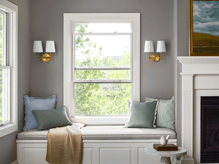 A living room with a window seat and a fireplace.