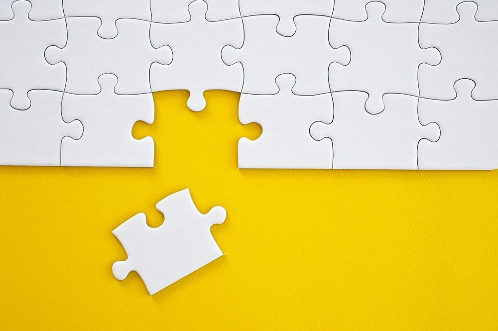 White puzzle pieces, one missing, on a yellow background.