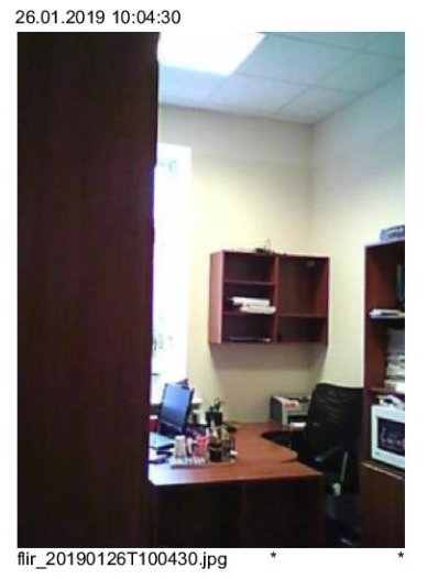 Office interior with desk, cabinets, and partially visible dark curtain.