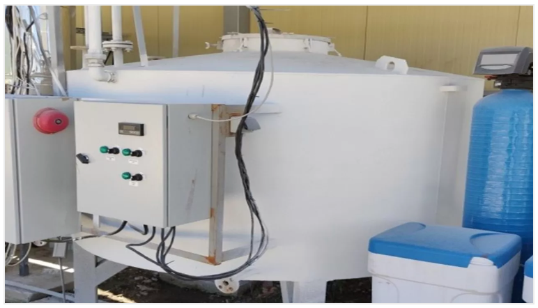 White industrial tank with control panel and water filtration components.