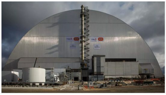 Large metal arch structure, the New Safe Confinement, covering the Chernobyl nuclear reactor.