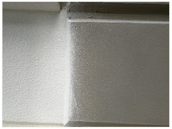 Two textured white wall sections meeting at a right angle, shadowed and softly lit.
